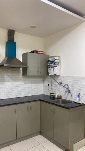 a kitchen with gray cabinets and a sink at The Horizon Blue in Zirakpur