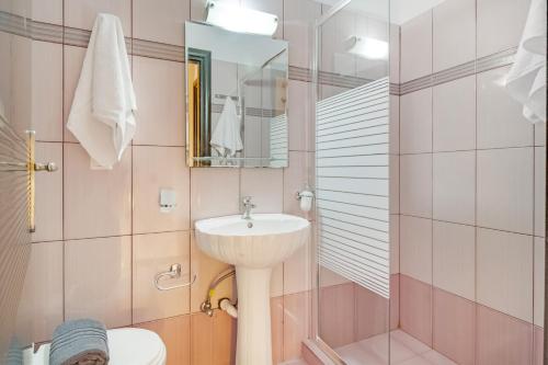 a bathroom with a sink and a toilet and a mirror at Villa prolithia 2 in Vlikhón