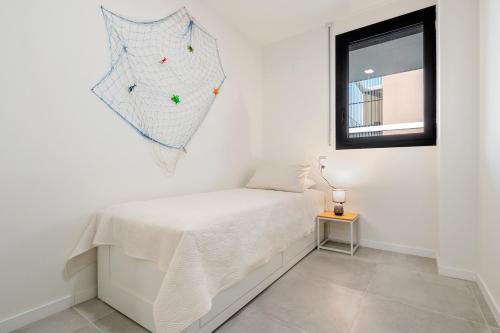 a white room with a bed and a window at Costa Dorada Perle in Calafell