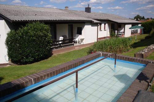 a swimming pool in front of a house at Pension Talblick in Höchst im Odenwald