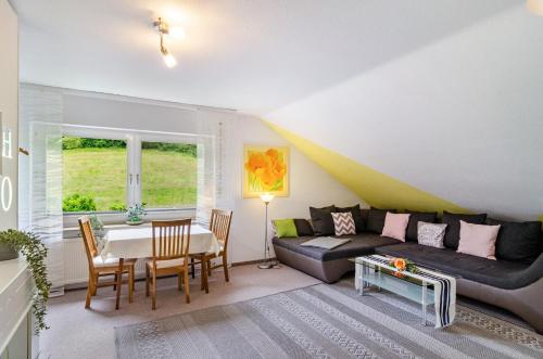 a living room with a couch and a table at Ferienwohnung am Rehwinkel in Fuldatal