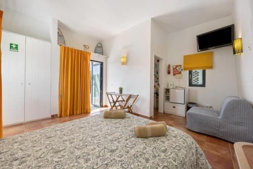 a living room with a large bed and a couch at Amado Properties in Carrapateira