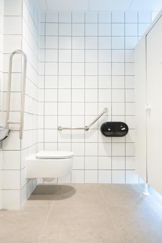 a white bathroom with a toilet and a sink at LPM Sporthotel Durbuy in Durbuy