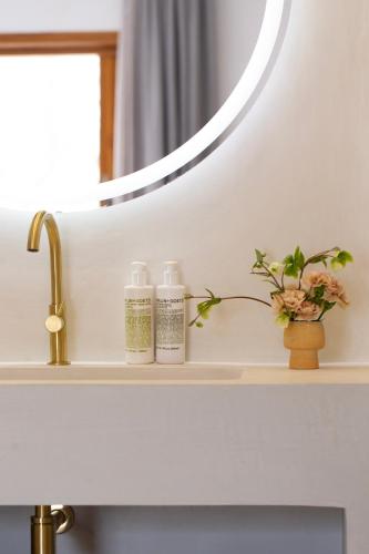 a bathroom sink with two bottles on a shelf under a mirror at Can Jaume by Ocean Drive in Ibiza Town