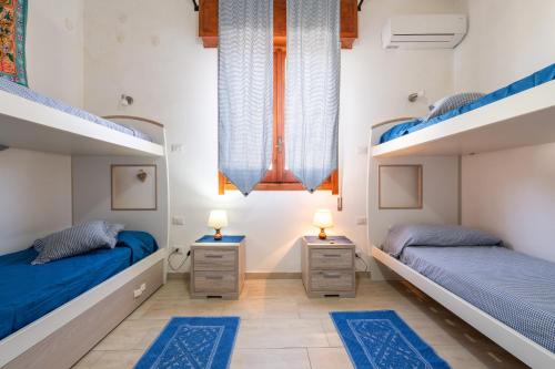 two beds in a room with blue sheets at Villa Rita in Flumini di Quartu