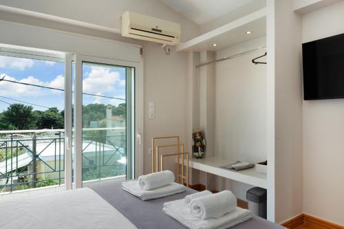 a bedroom with a bed and a large window at Artemida Beach House in Artemida