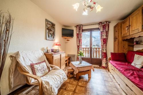 a living room with a couch and a table at Morillon - Studio 4 personnes in Morillon