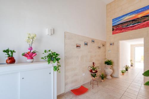 a room with potted plants and a painting on the wall at San Giorgio Rooms in Cavallino di Lecce