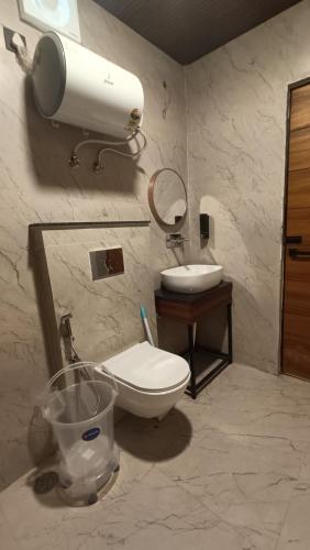 a bathroom with a toilet and a sink at Aqua Forest River Resort in Bijni