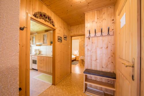 a large kitchen with wooden walls and a door at Obermarhof Gsies in Prateria