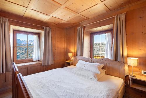 ein Schlafzimmer mit einem Bett in einem Holzzimmer in der Unterkunft Ciablun in Wengen