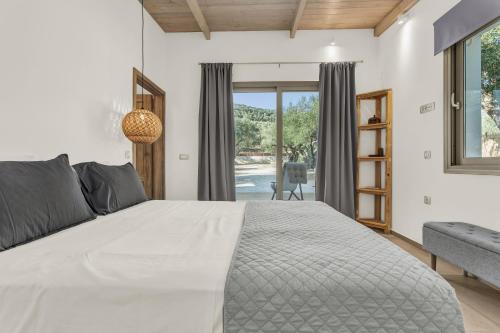 a bedroom with a large bed and a window at Natura Oliva House in Alikanas