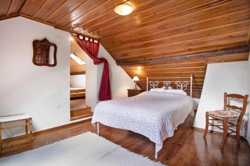 a bedroom with a bed and a wooden ceiling at Casa do Largo in Mendiga