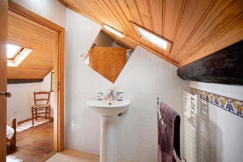 a bathroom with a sink and a wooden ceiling at Casa do Largo in Mendiga