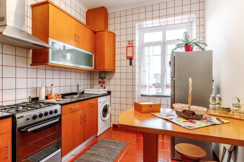 a kitchen with wooden cabinets and a stainless steel refrigerator at Garden View Apartment in Horta