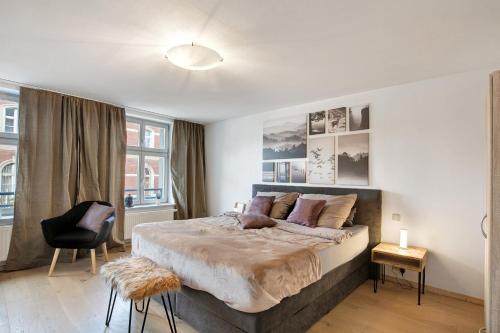 a bedroom with a large bed and a chair at Klosterperle in Neuruppin