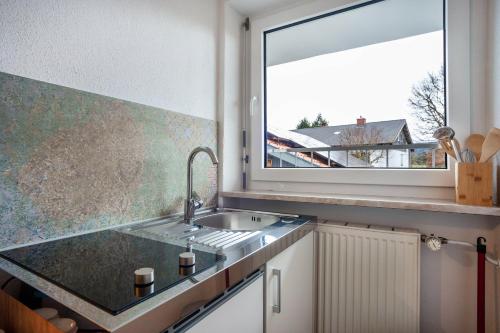 a kitchen with a sink and a window at Tinas Ferienwohnung in Hergensweiler