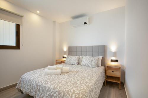 a bedroom with a white bed with two pillows at Apartamento Avenida Marítima in Candelaria