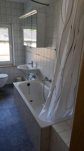 a bathroom with a bath tub and a sink at Das Landhaus Wohnung 2 in Kirch Mulsow