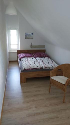 a bedroom with a bed and a chair and a window at Das Landhaus Wohnung 2 in Kirch Mulsow