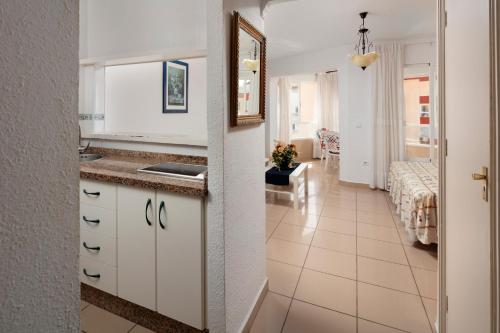 a kitchen with a sink and a room with a bed at Estudios 88 in Torrox
