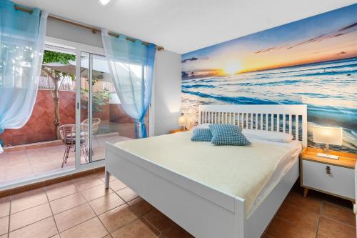 a bedroom with a bed and a painting of the ocean at Casa Deti in Roses