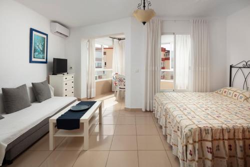 a hotel room with two beds and a couch at Estudios 88 in Torrox