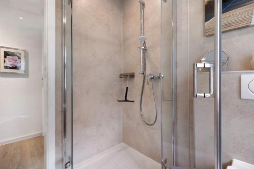 a shower with a glass door in a bathroom at Ferienhaus Apfelzauber in Twielenfleth