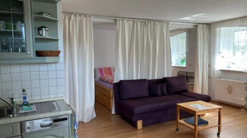 a living room with a purple couch and a table at Villa Fichteneck in Oberhof