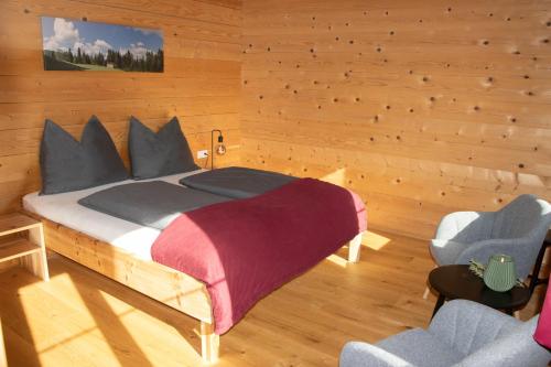 a bedroom with a bed and two chairs at Ferienwohnung Naturnah in Dalaas