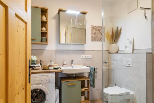 a bathroom with a sink and a washing machine at Ferienwohnung z'Dandlberg in Tittmoning