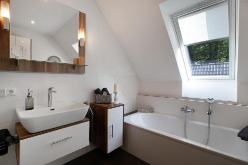 a bathroom with a sink and a tub and a window at Kleine Nock in Burg