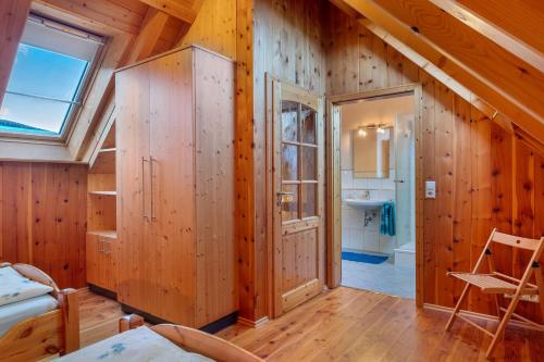 a room with wooden walls and a bathroom with a window at Geigerseppleshof in Mühlenbach