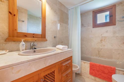a bathroom with a sink and a toilet and a mirror at Montemar 36 in Port de Soller