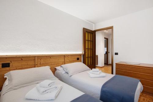 two beds in a room with towels on them at Maison Le Cré Appartamento 5 in Introd