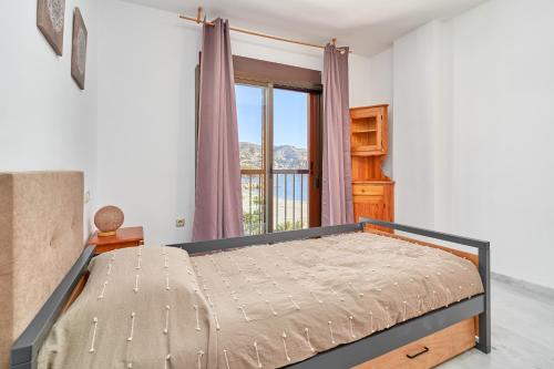 a bedroom with a bed and a window at Argali Beach Almuñecar in Almuñécar