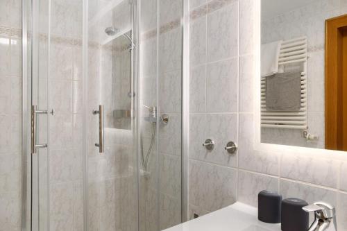 a bathroom with a shower with a sink and a mirror at Ferienwohnung Reschbergwies'n in Farchant