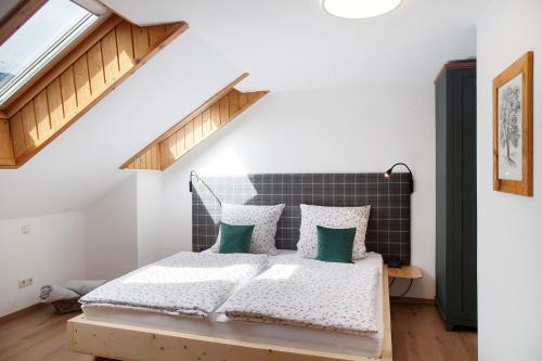 a bedroom with a bed with green pillows at Ferienwohnung Reschbergwies'n in Farchant