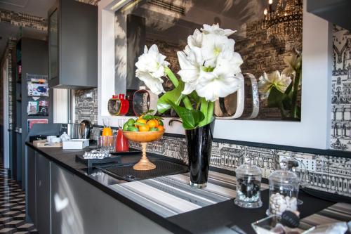 a vase filled with white flowers on a counter at Rarity Suites in Rome