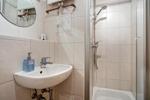 a white bathroom with a sink and a shower at Ferienwohnung Rügen in Stralsund