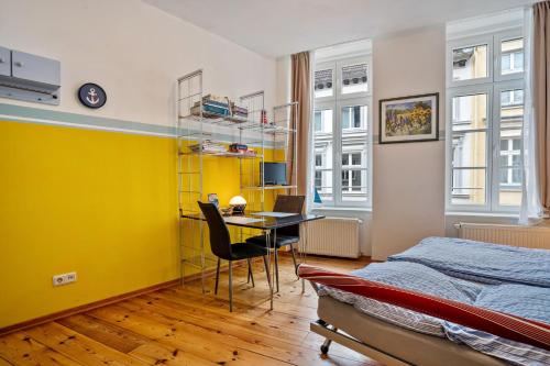 a bedroom with a yellow wall and a table and chairs at Ferienwohnung Rügen in Stralsund