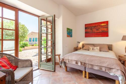 a bedroom with a bed and a sliding glass door at Logement de charme les Araucarias in La Garde