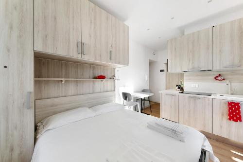 a bedroom with a white bed and wooden cabinets at Dolomiti e Misurina My dreams in Misurina