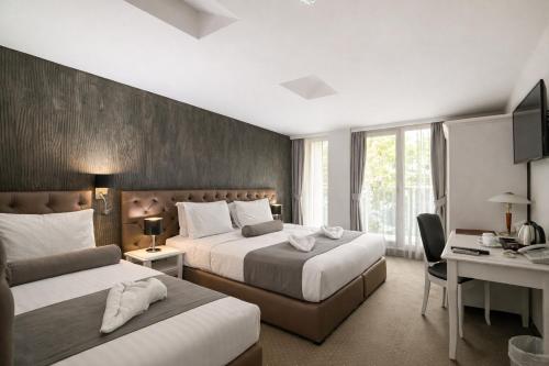 a hotel room with two beds and a desk at Hotel Alexandar II in Skopje