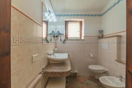 a bathroom with a sink and a toilet and a mirror at Villa Marisol Agrustos in Budoni