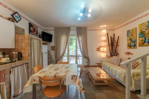 a kitchen and living room with a table and a couch at Villa Marisol Agrustos in Budoni