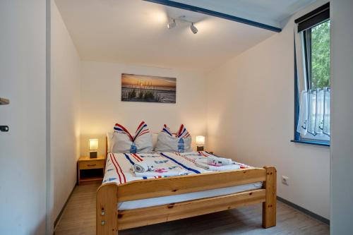 a bedroom with a bed in a room with a window at Bungalow Kay, Bgl 4 in Dranske