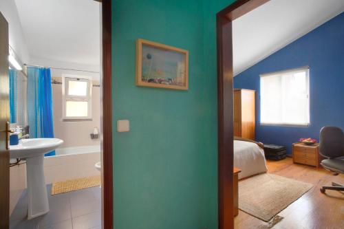 a bathroom with a green wall and a sink at Bela Vigia in Jardim do Mar
