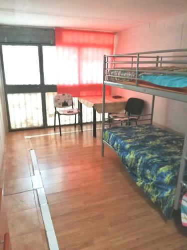 a room with bunk beds and a table and a desk at Roses in Roses
