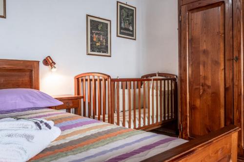 a bedroom with a bed and a wooden crib at Casaletto della musica in Viterbo